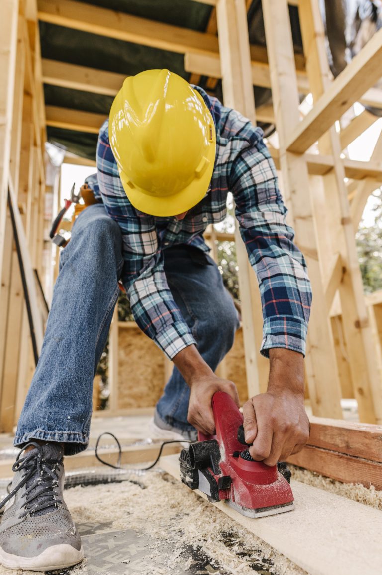 construction-worker-with-hard-hat-sanding-down-wood-piece